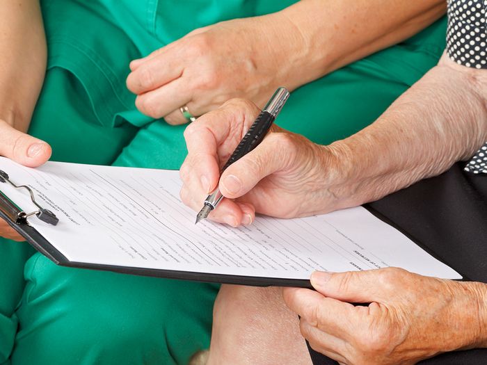 Woman signing a medical form
