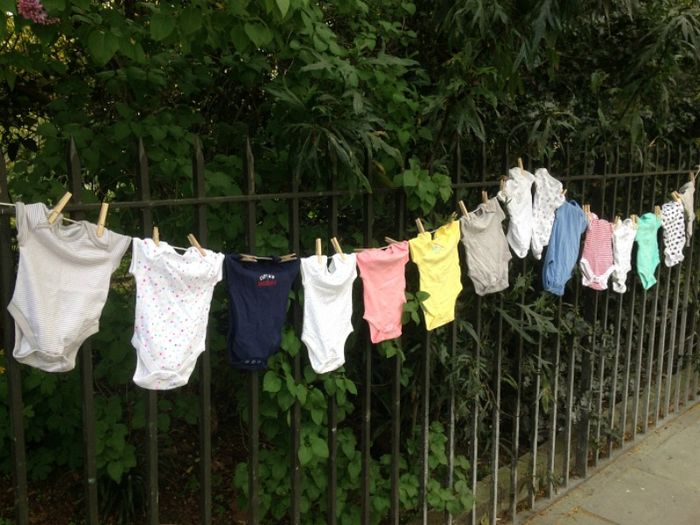 Baby clothes pegged to a washing line in an urban street
