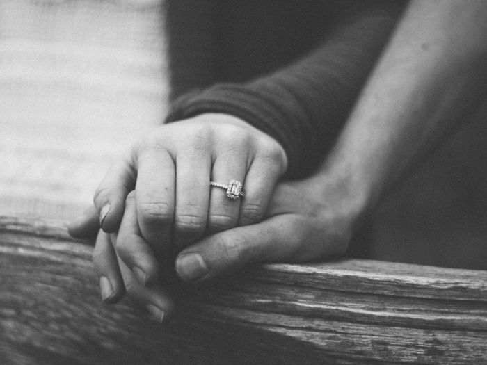 A woman clasps a friend's hand to offer comfort and reassurance