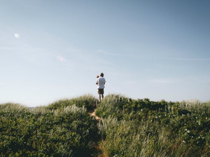 Man walking with toddler over a hill