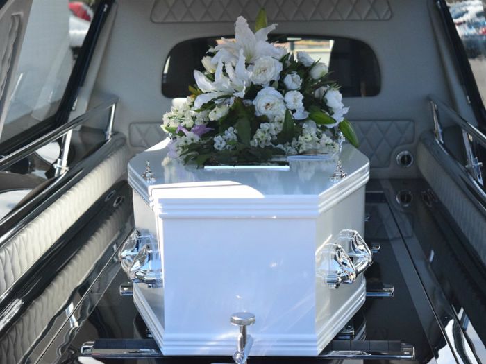 Coffin with floral presentation in hearse