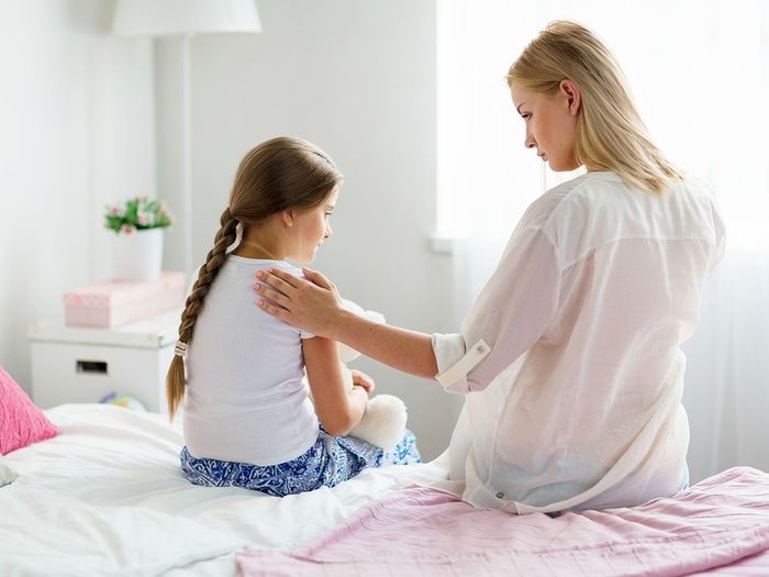 A young girl shares her worries with her mum