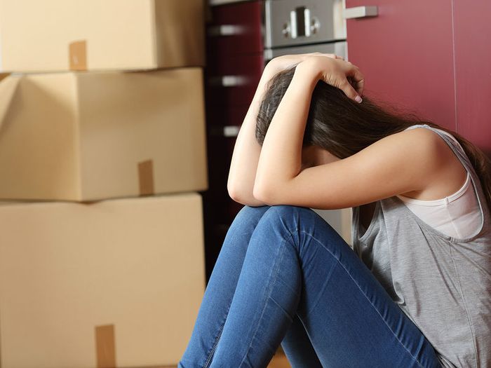 Widowed woman being evicted from her home, sat on the floor crying