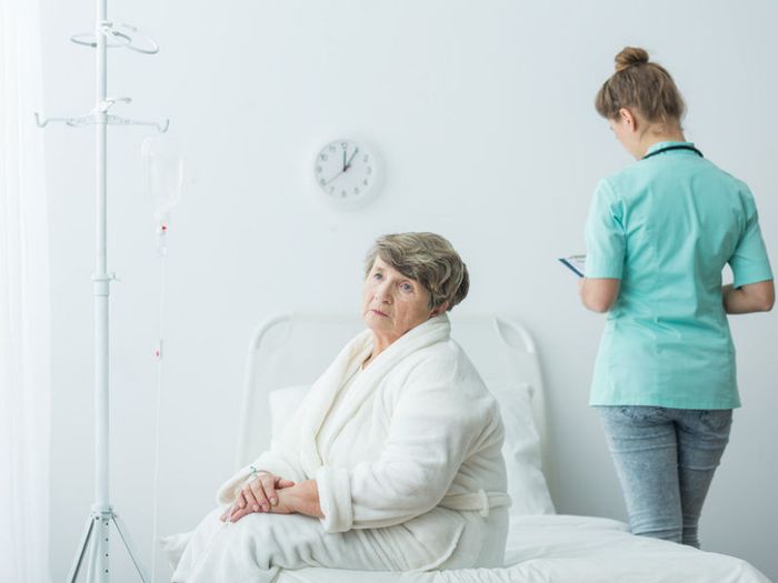 Elderly woman sitting on hospital bed