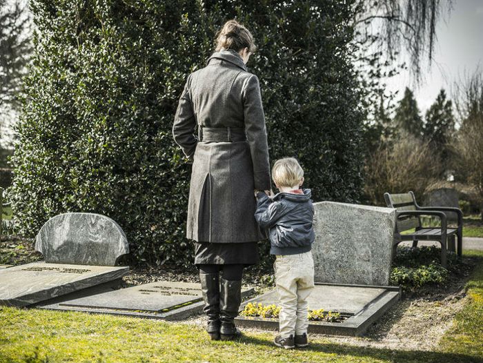 Woman and child standing at grave