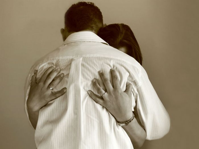 A grieving couple hug each other