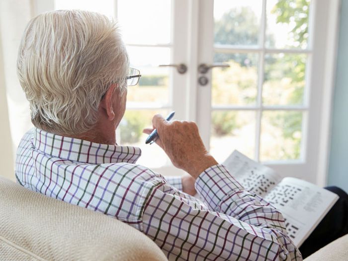 A older man in an armchair gazes out of the window
