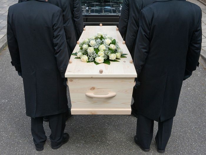 Pallbearers carrying a coffin to the hearse