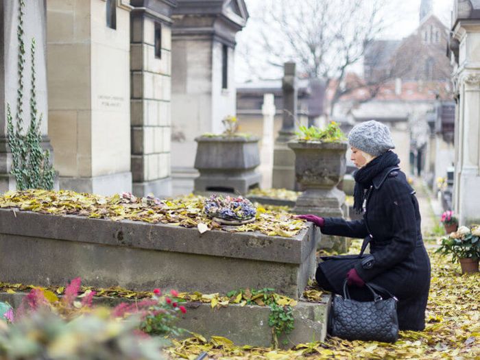 Grieving woman visiting loved one's grave