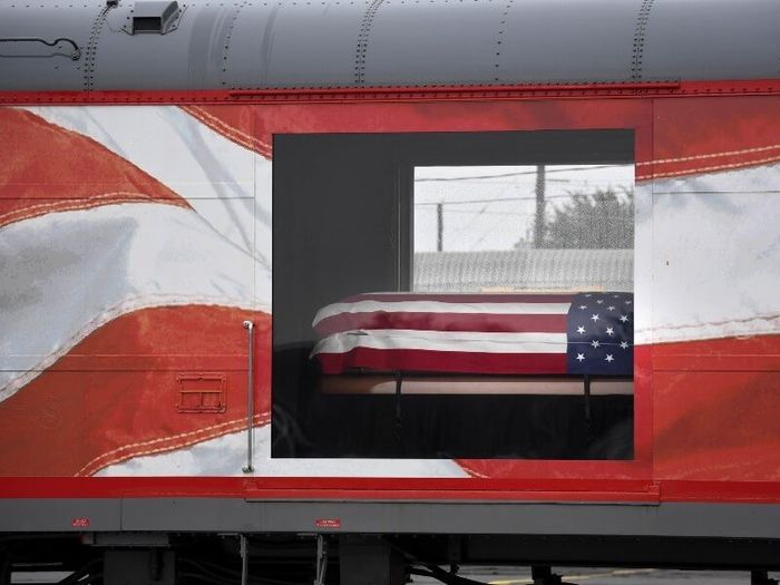 Close-up of carriage on George H.W. Bush's funeral train, with doors opening showing his coffin covered with the American flag