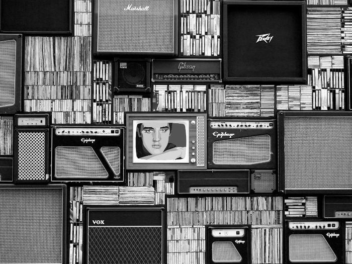 A wall full of CDs, vinyl records, TVs and amplifiers