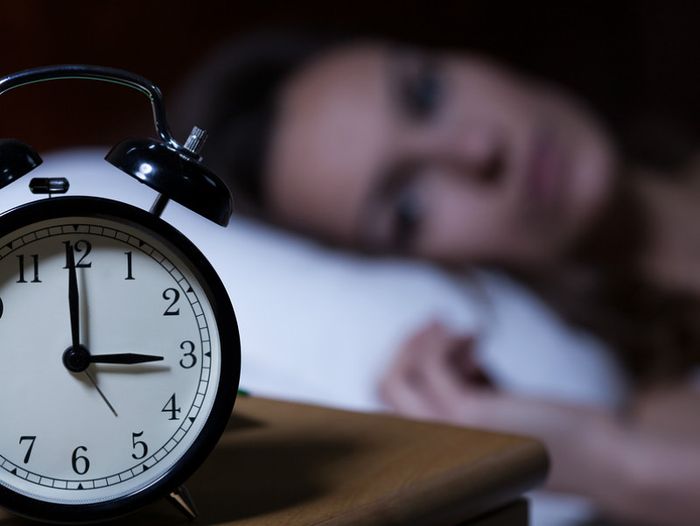 Woman lying in bed unable to sleep due to grief